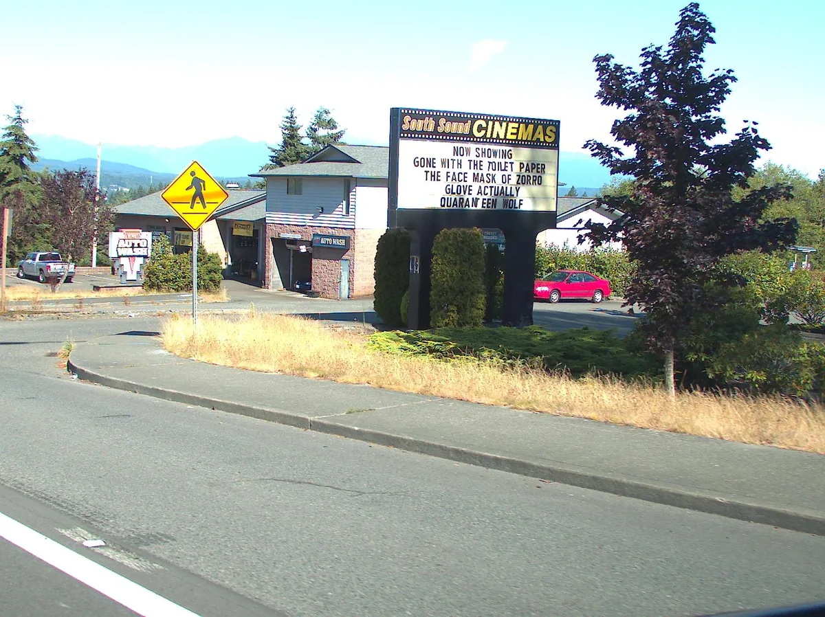 A lit movie-theater marquee at dusk