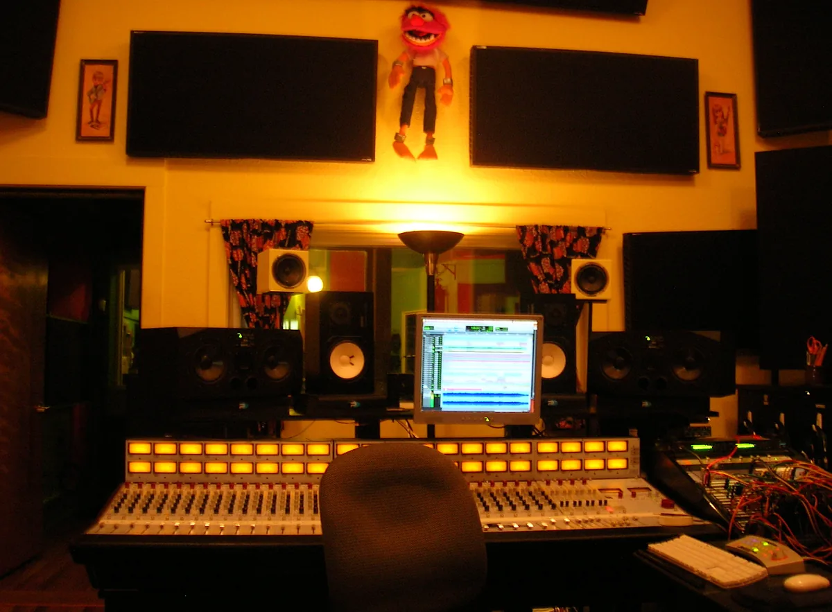 A record producer working at a studio mixing console